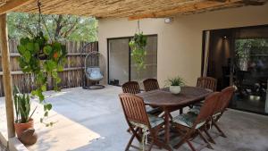 a patio with a wooden table and chairs at Thornhill Safari Lodge in Guernsey Nature Reserve
