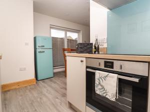 a kitchen with a stove and a blue refrigerator at Dawsons Cottage in Lancaster