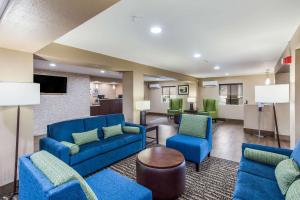 a lobby with blue couches and chairs and a table at Quality Inn in Charleston