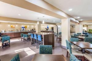 Un restaurante con mesas y sillas y un bar. en Quality Inn Charleston South, en Charleston