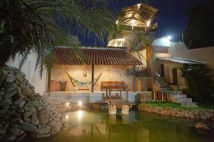 a house with a pool of water in front of it at Pousada nossas Raízes in Porto Velho