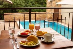 a table with two plates of food and two glasses of juice at Pousada nossas Raízes in Porto Velho