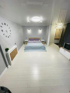 sypialnia z łóżkiem i zegarem na ścianie w obiekcie Студия LUX в центре города w mieście Krzywy Róg