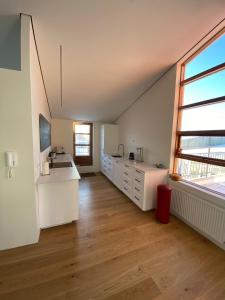 a kitchen with white cabinets and a large window at Reykjavík Central Apartments in Reykjavík