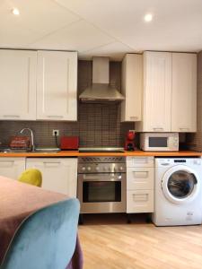 a kitchen with white cabinets and a stove top oven at Fridda House Atocha Madrid in Madrid