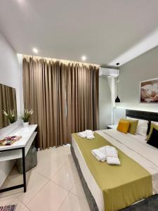 1 dormitorio con 2 camas, mesa y cortinas en Relax Apts Saranda, en Sarandë