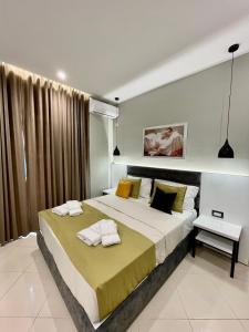 1 dormitorio con 1 cama grande y 2 toallas. en Relax Apts Saranda, en Sarandë
