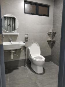 a bathroom with a toilet and a sink and a mirror at Lakeview Duplex Apartment Free WiFi and Netflix in Cyberjaya +11 photos