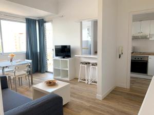 Una sala de estar con un sofá y una mesa y una cocina. en Apartamentos Bruja, en Santa Cruz de Tenerife