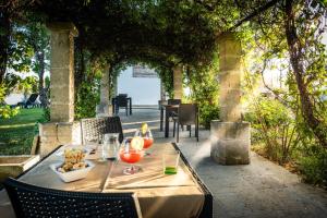 una mesa con comida y bebida en el patio en L'Ecce Sphero, en Acquarica