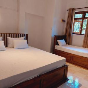 1 dormitorio con 2 camas y ventana en Golden Villa Kandy, en Kandy