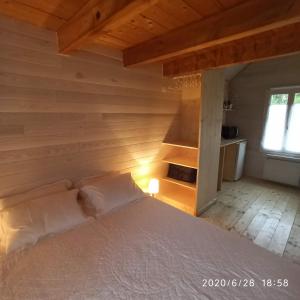 a bed in a room with a wooden wall at Une Tiny House à découvrir au cœur de la cité ! in Contrexéville