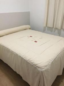 a bed with a white blanket on top of it at Hostal VILLA CARBULA in Almodóvar del Río