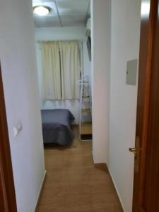 - un couloir menant à une chambre dotée d'un lit dans l'établissement Hostal VILLA CARBULA, à Almodóvar del Río