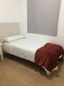 a bed with a blanket on it in a room at Hostal VILLA CARBULA in Almodóvar del Río