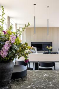 a kitchen with a table with a vase of flowers at GLUK in Zonnebeke