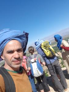 a group of people walking up a mountain with backpacks at La maison des amis in Taroudant