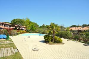 una piscina vuota in un cortile con alberi e case di Marina Punta Verde a Lignano Sabbiadoro