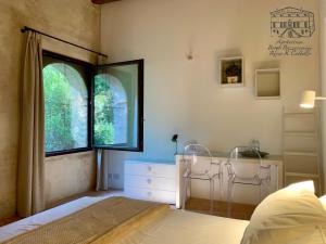 een slaapkamer met een bed, een raam en een dressoir bij Agriturismo Borgo Buzzaccarini Rocca di Castello in Monselice