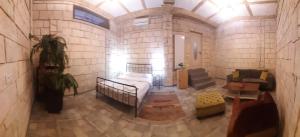 a large room with a bed in a brick wall at Retro Hostel & Tours in Yerevan