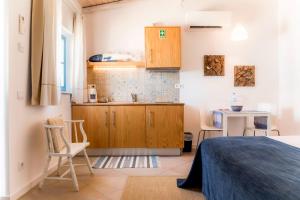 a small kitchen with a bed and a table at Cercas Velhas in Sagres