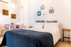 um quarto com uma cama com um cobertor azul em Cercas Velhas em Sagres