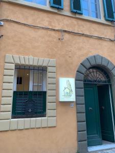 een gebouw met een groene deur en een raam bij Casa Carducci 33 in Pisa