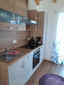 a kitchen with white cabinets and a sink and a stove at Gästehaus Andreas in Schönsee