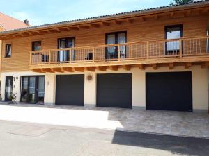 a house with three garage doors and a balcony at Gästehaus Andreas in Schönsee