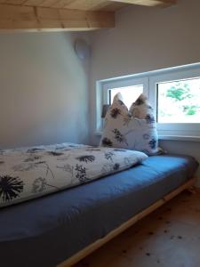 a bed with pillows sitting next to a window at Gästehaus Andreas in Schönsee