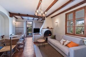 ein Wohnzimmer und eine Küche mit einem Sofa und einem Tisch in der Unterkunft Casa degli Ulivi in San Felice del Benaco