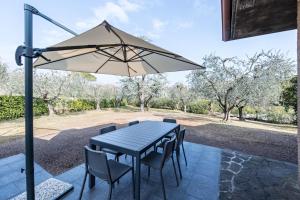 einem schwarzen Tisch mit Stühlen und einem Sonnenschirm in der Unterkunft Casa degli Ulivi in San Felice del Benaco