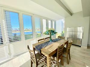 a dining room with a table and chairs and windows at Knockoff at Kingston Place Marina in Jeffreys Bay