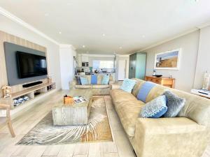 a living room with a couch and a tv at Knockoff at Kingston Place Marina in Jeffreys Bay