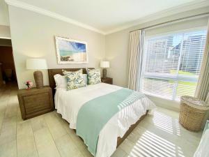 a bedroom with a bed and a large window at Knockoff at Kingston Place Marina in Jeffreys Bay