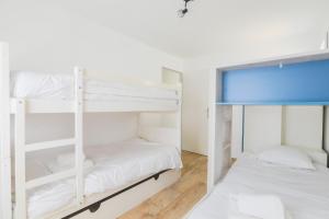 a bedroom with two bunk beds and a window at Maison tout confort a deux pas de la piste cyclable in Le Bois-Plage-en-Ré