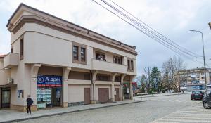 a man standing in front of a building on a street at Hotel Central in Karlovo