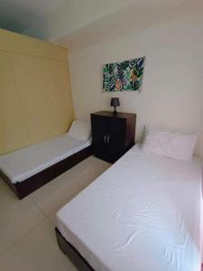 two beds in a room with white sheets at Wind Residence T4- I Near TAAL VIEW at sky lounge in Nasugbu