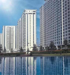 two tall buildings in front of a large pool of water at Wind Residence T4- I Near TAAL VIEW at sky lounge in Nasugbu