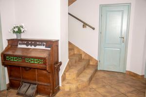 a hallway with a staircase with a blue door at Weranda Rooms in Tychy