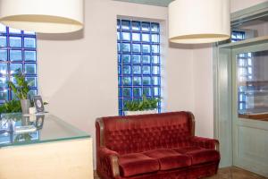 una sedia in pelle rossa in una stanza con finestre di Weranda Rooms a Tychy