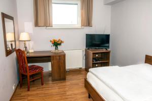 a bedroom with a desk and a bed and a television at Weranda Rooms in Tychy