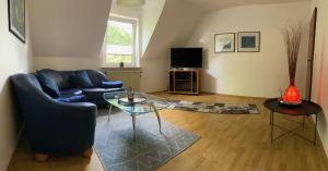 a living room with a blue couch and a glass table at Ferienhaus Gartenblick in Brieden in Brieden