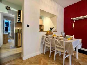 una cucina e una sala da pranzo con tavolo e sedie bianchi di Hello Bayeux - Confort dans le coeur de la ville a Bayeux