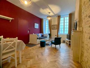 un soggiorno con pareti rosse e pavimenti in legno di Hello Bayeux - Confort dans le coeur de la ville a Bayeux