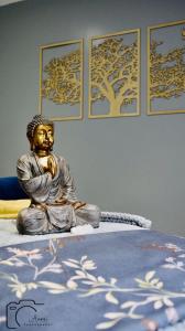 a statue of a buddha sitting on a bed at Cripps Farm Holiday Lets in Cote