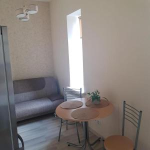 uma sala de estar com uma mesa e cadeiras e um sofá em Sonata em Liepāja