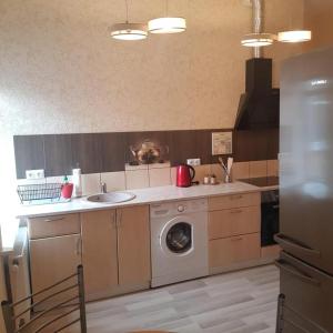 uma cozinha com uma máquina de lavar roupa e um lavatório em Sonata em Liepāja