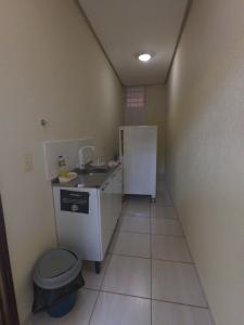 a small bathroom with a sink and a refrigerator at Suíte na Canastra in São Roque de Minas