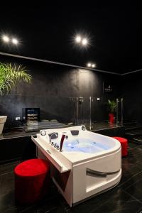 a bathroom with a white tub and red stools at Marmur Suite in Palermo